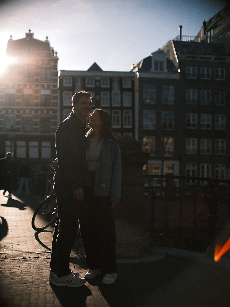 Engagement SP13 Cinematisch tegenlichtportret van een koppel dat elkaar kust op een Amsterdamse brug tijdens het gouden uur