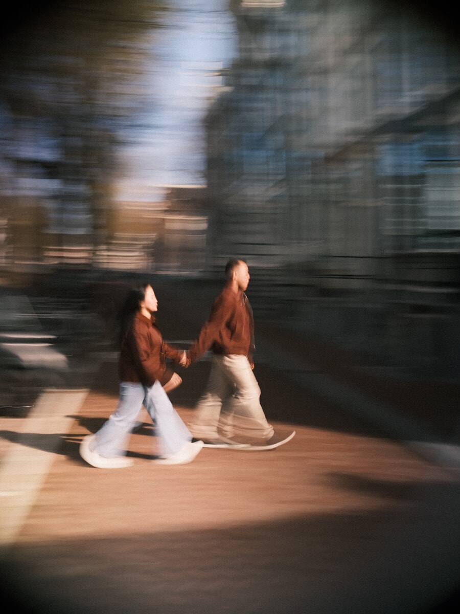 Engagement SP7 Sfeervolle bewegingsfoto van een stel dat hand in hand door Amsterdam loopt tijdens hun verlovingsshoot