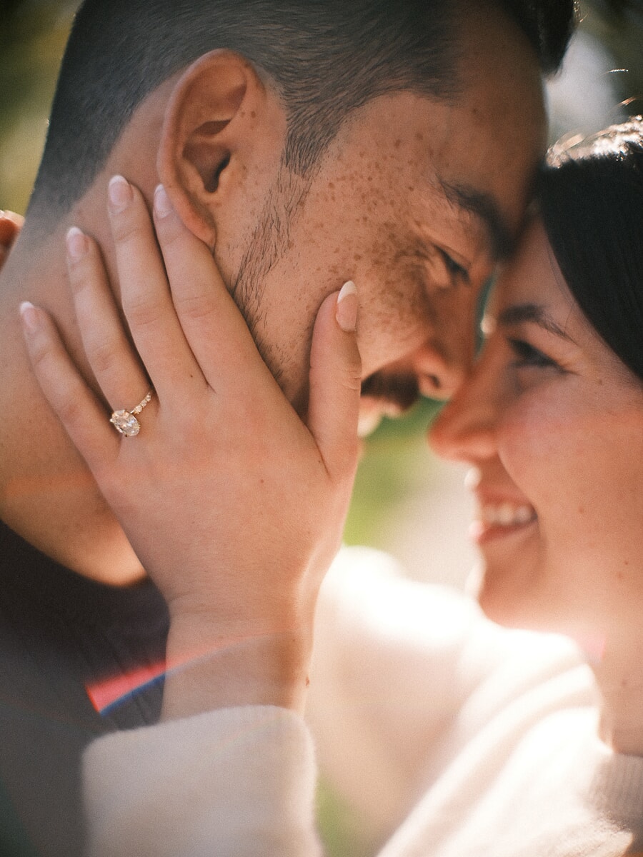Proposal SP17 Sensuele close-up van een stel met de voorhoofden tegen elkaar, haar hand met verlovingsring rond zijn gezicht