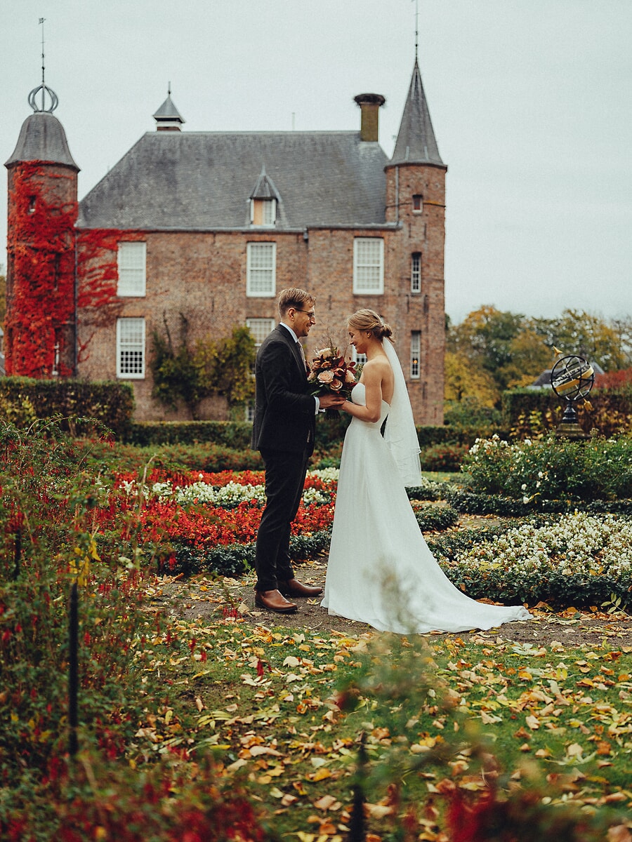 Wedding Ceremony SP20 Bruid en bruidegom tegenover elkaar voor een Nederlands kasteel met rode klimop in een herfsttuin, vastgelegd door een trouwfotograaf in Amsterdam