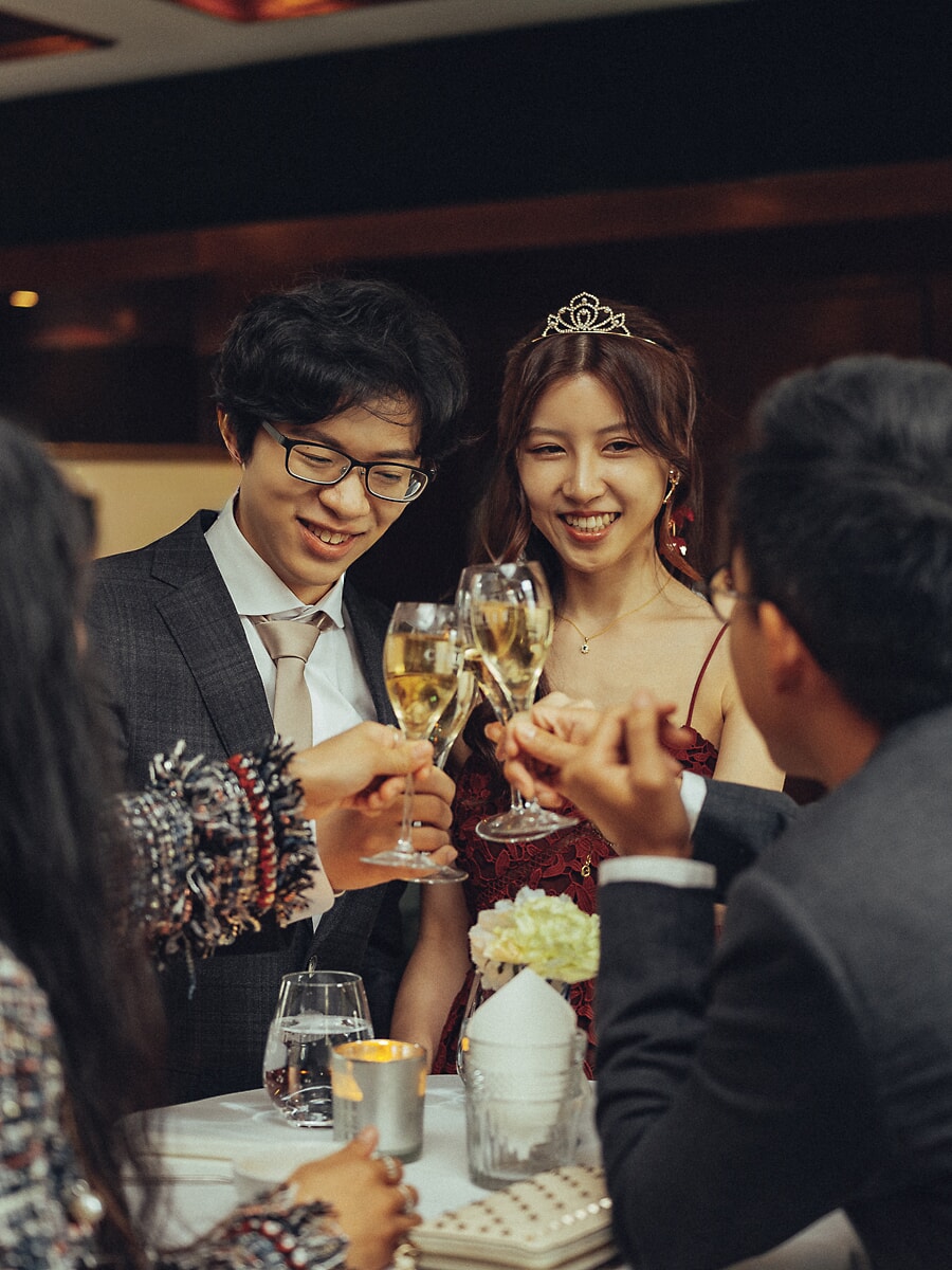 Wedding Ceremony SP25 Met geheven champagneglazen proost het stel met gasten bij kaarslicht, de bruid met tiara, van een trouwfotograaf in Amsterdam