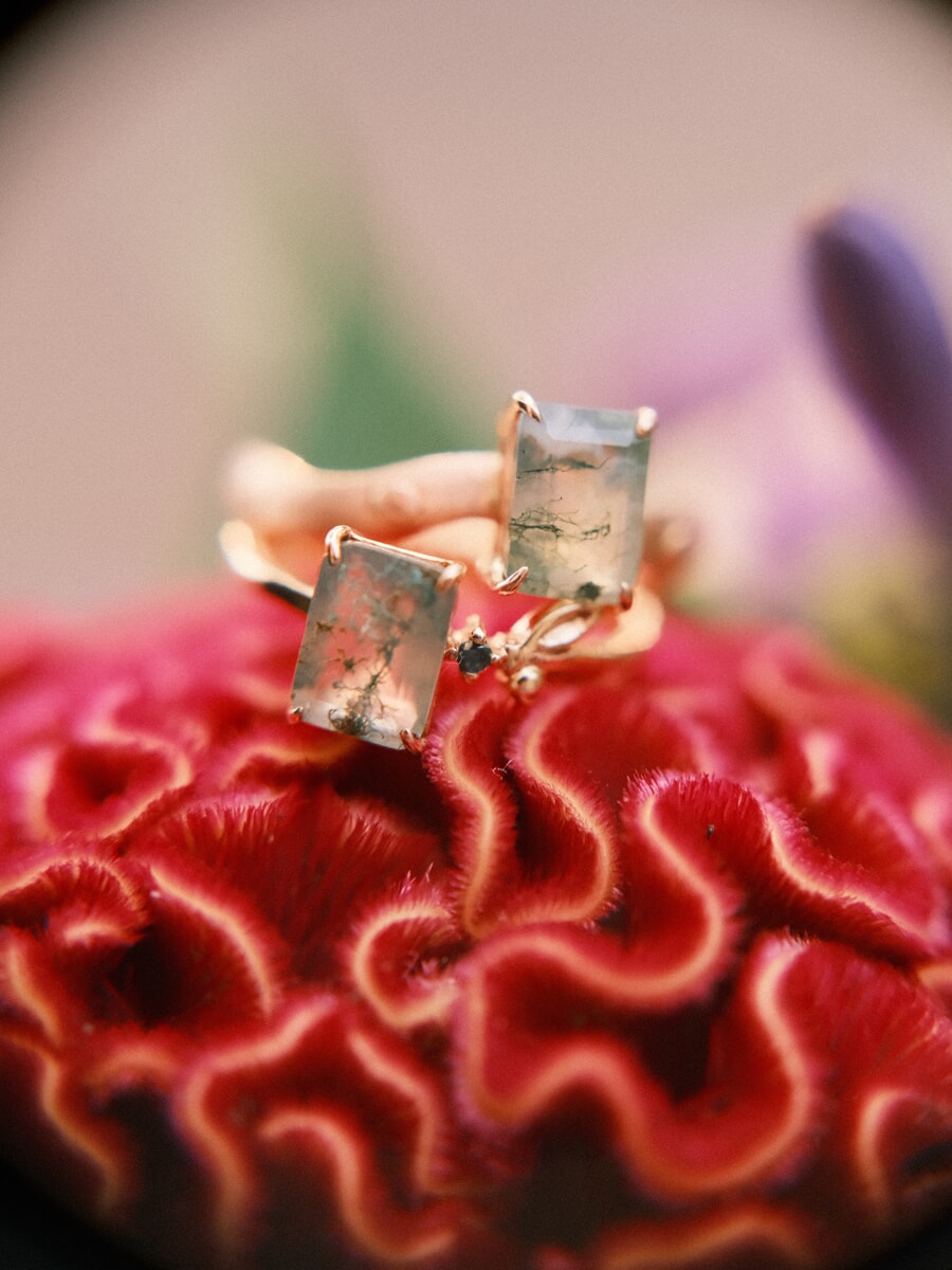 Wedding Bridal SP15 Close-up van twee gouden ringen met mosagaat op een dieprode celosia, een fijn detail uit de bruidsfotosessie