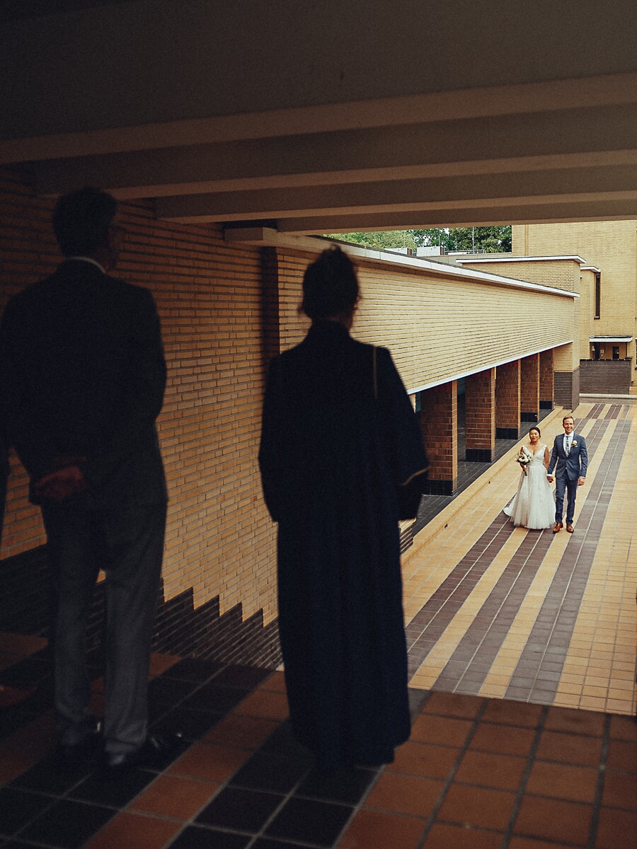 Wedding SP30 Tussen twee silhouetten door fotografeert een trouwfotograaf in Amsterdam het pasgetrouwde stel op een gestreept klinkerpad